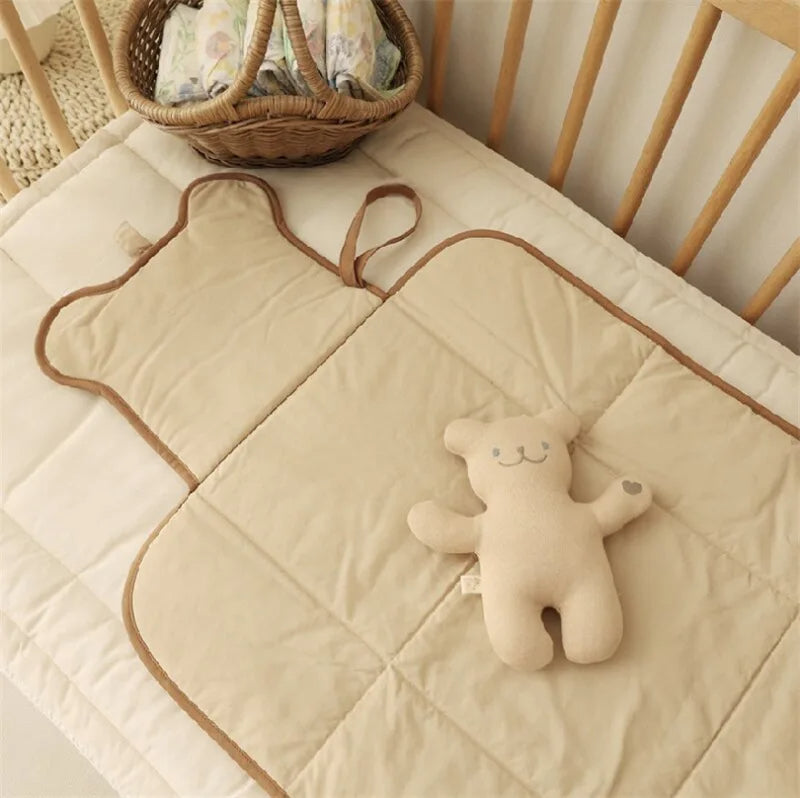 tapis à langer nomade déplié sur le lit